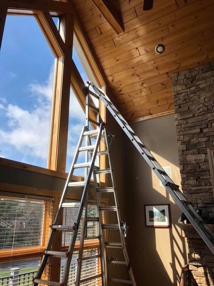 Professional window tinting installation on two-story architectural windows in Delaware home